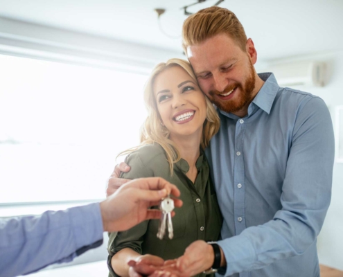 Happy couple getting keys to new house